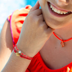 VEVA - Pulsera inicial mini dorada sobre nácar
